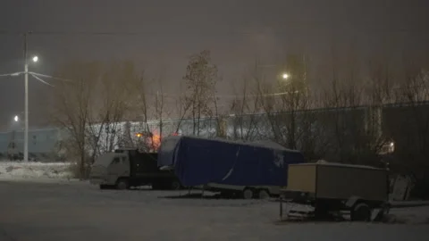 Train driving past old trailers on foggy night in the snow Stock Footage 225418050