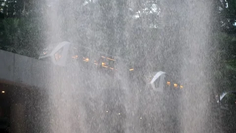 A train is driving through Vortex fountain at the heart of Jewel Changi Airport. Stock-Footage 318262548
