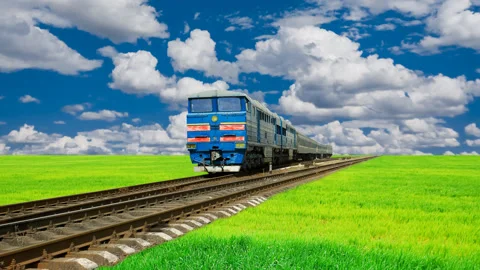 Train from far among green fields under blue cloudy sky Stock Footage 152385678