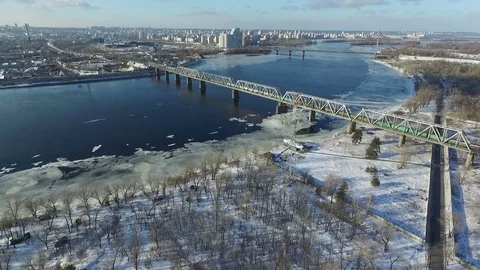 The train goes over a bridge across the river. Aerial view. Stock Footage 72512891