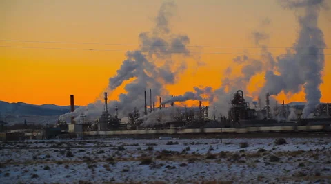 Train going by a factory at sunset Stock Footage 52454094