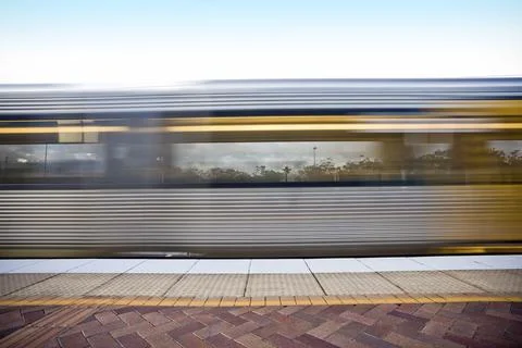 Train going fast past a train station Stock Photos