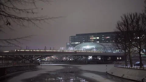 Train going into Hauptbahnhof Berlin at winter with canal of ice in front Stock Footage 331599436
