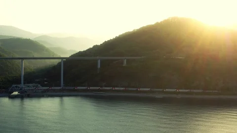 A train is going next to the green hills and the sea Stock Footage 101575948