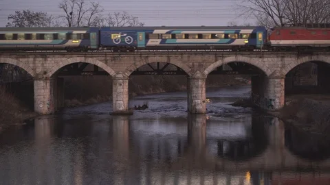 Train is going over the bridge. Reflection of the passing train in the river. Vídeo Stock 127354722