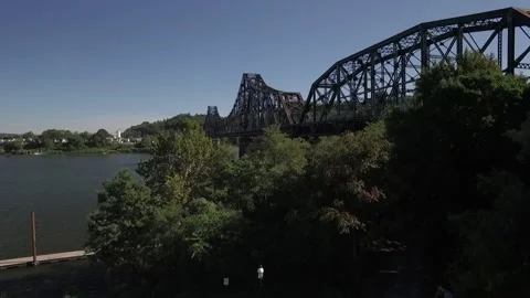 Train going over an old bridge with a perfect blue sky on a summers day Stock Footage 145096877