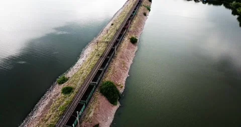 Train going over railway over the river in Ukraine. 4K drone video Stock Footage 137272574