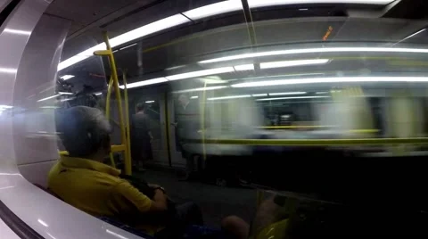 Train interior with passengers reflected off windows as two trains pass. Видео 63749925