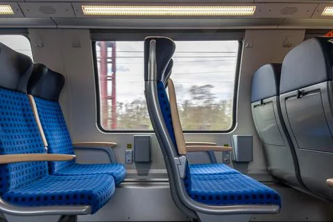 Train interior with seats and large window in motion. Travel transport concep Stock Photos