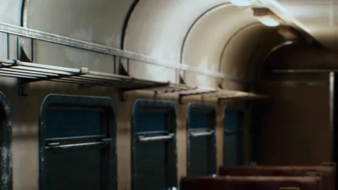 Train interior shows empty seats and windows in a dimly lit setting Stock Footage 339497882