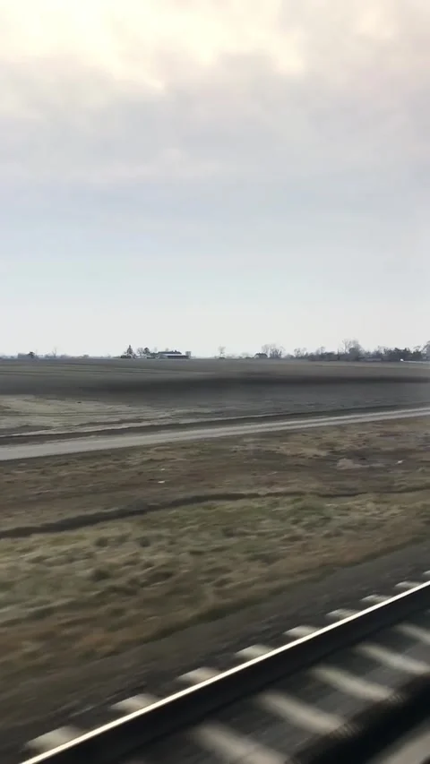 Train Journey Through Rural Landscape with Overcast Sky Stock Footage 338126347