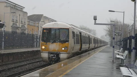 A train leaving a station during a snowfall. Stock Footage 116787588