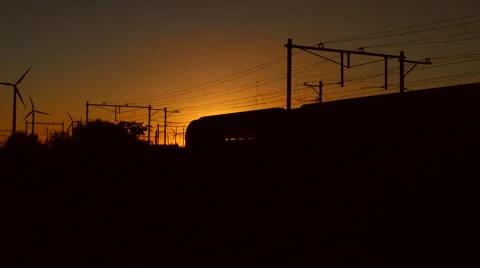 Train leaving the trainstation and crossing the railway, at sunset. Stock Footage 65879444