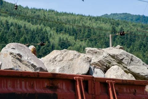 The train is loaded with huge chunks of granite, cargo platform with stones 스톡 사진