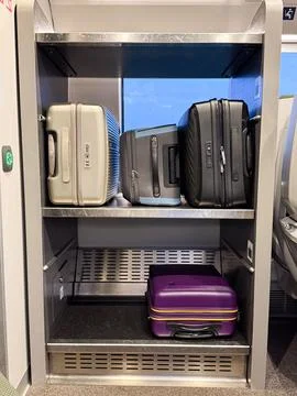 A train luggage rack with multiple modern suitcases in various colors and s.. Stock Photos