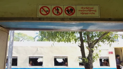 Train in motion through window, no kissing, smoking, littering signs, Yangon Видео 78281373