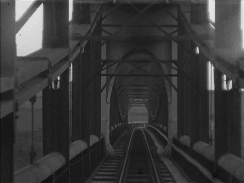 Train moves along a single track suspension bridge, United Kingdom, 1901 Stock Footage 132021835