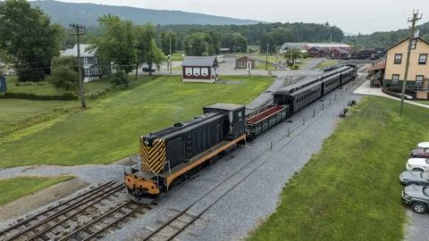 Train Moves Through a Train Station in a Rural Area on a Clear Day With Gre.. Fotos Stock