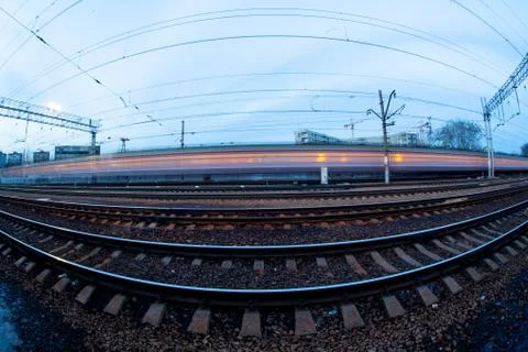 Train moving along platform in twilight  Stock Photos