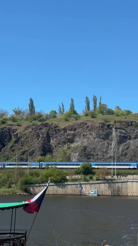 Train moving along railway track, transporting passenger near flowing river, Stock Footage 333699828