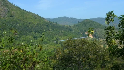 Train moving between mountains green trees Stock Footage 98587819