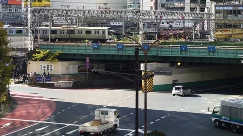 Train moving on railway bridge while vehicle passing on road Stock Footage