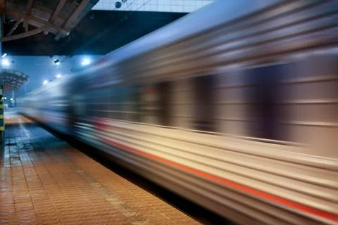 Train moving at station along platform Stock Photos