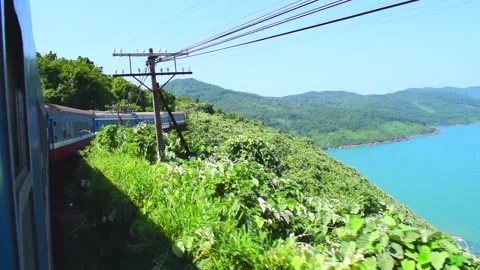Train moving through the dense Vietnamese jungle on a mountain near the seaside Stock Footage 144909337