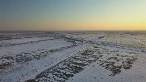The train is moving through snow covered fields at sunset Stock Footage 123101766