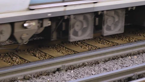 Train with Multiple Carriages Moving Along Iron Rail Tracks with Wheels Turning Stock Footage 320610600
