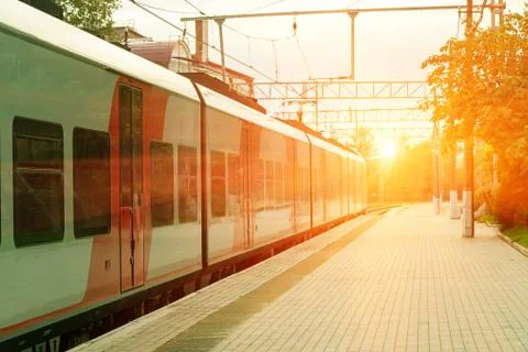 Train near the empty train platform on a summer evening Stock Photos