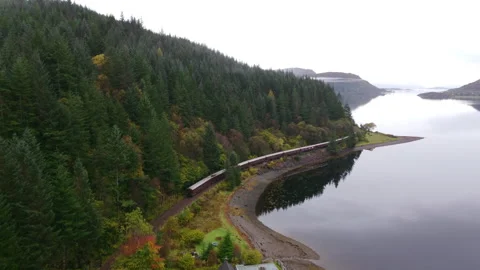 Train next to a forest and a lake in autumn. Aerial view Stockbeeldmateriaal 258305139