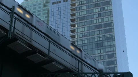 A Train or Subway in New York Glides over Monorail Tracks with Distant Skysc Stock Footage 326373725