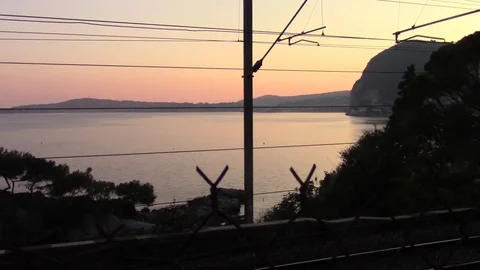 Train overhead lines with a quiet sea in the background Stock Footage 74977762