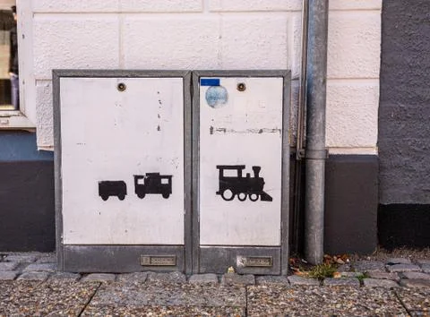 A train painted in black on an electrical box in the street. Stock Photos