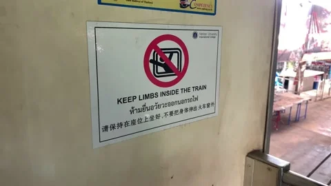 Train park at Maeklong Station. "KEEP LIMBS INSIDE THE TRAIN" sign - day Video stock 196268702