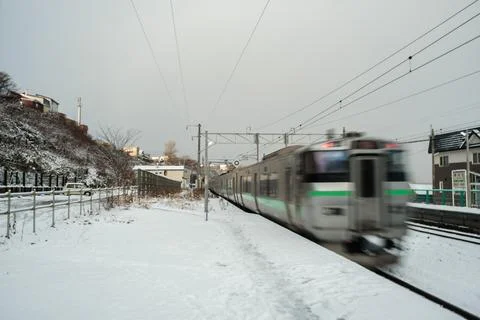 Train passed by snow-covered platform of JR Asari Station. Stock Photos