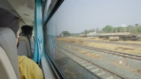 Train passenger sitting by the window of the train watching the outside scene Stock Footage 239985984
