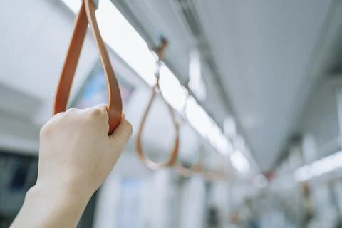 Train passenger standing handle hook on the railing bar, using to gripping fo Photos