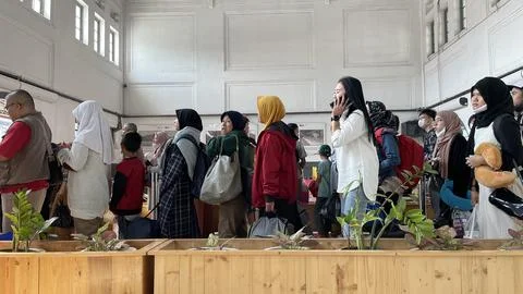 Train passengers queue to enter the train departure waiting room Stock Photos