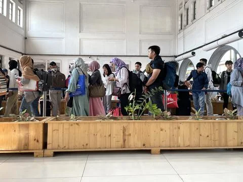 Train passengers queue to enter the train departure waiting room Foto stock