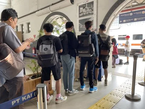 Train passengers queue to enter the train departure waiting room Stock Photos