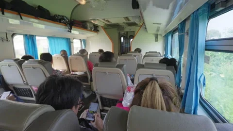 Train passengers sitting on their assigned seats on a express train Stock Footage 239985648