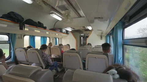 Train passengers sitting on their assigned seats on a express train Stock Footage 239985905