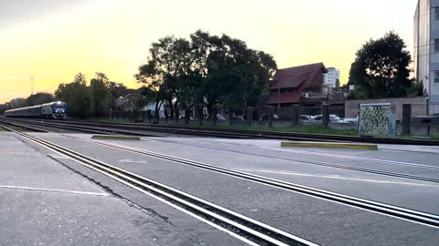 The train passes along the railway tracks at sunset, an empty platform, calmness Stock Footage 246404572