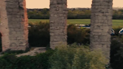 A train passes by an ancient roman's duct at sunset, Rome Video stock 128357231
