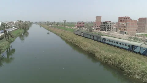 Train passes by a Canal on its way to another city in Egypt, 12 March 2024 Stock Footage 285896170