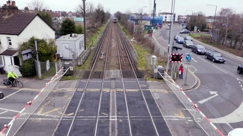 A Train passes a Level crossing in London Stock Footage 103169987