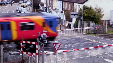 A Train passes a Level crossing in London Stock Footage 103170192