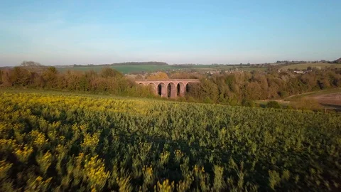 Train passes over Eynsford Viaduct and Rapeseed Field Stock Footage 128937781